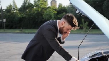 Adam arabanın kaputunu açıyor. Beklenmedik bir durum. 