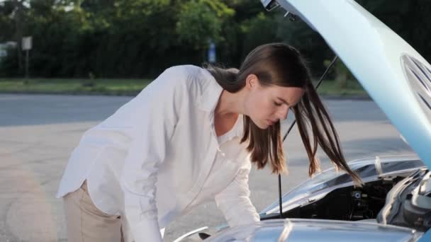 Ung upprörd kvinna förare står nära den trasiga bilen med öppen huva r olycka. — Stockvideo