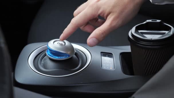 Vista ritagliata mano maschile in un'auto premendo il pulsante parcheggio in auto elettrica. — Video Stock