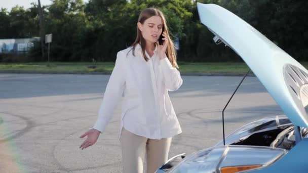 紧张的女人在智能手机上解释坏了的车的问题. — 图库视频影像
