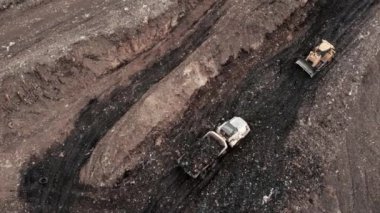Çöp yığını içinde giden çöp kamyonunun insansız hava aracı görüntüsü..