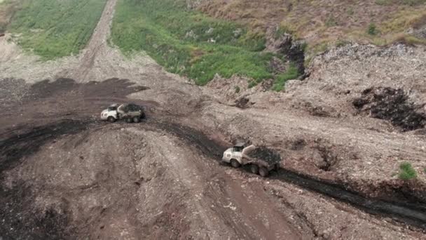 Két kukásautó egy halom szeméttel, ökológiai katasztrófa koncepcióval.. — Stock videók