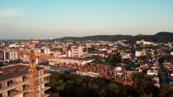 Gran grúa torre industrial con cielo azul y paisaje urbano sobre fondo. — Vídeos de Stock