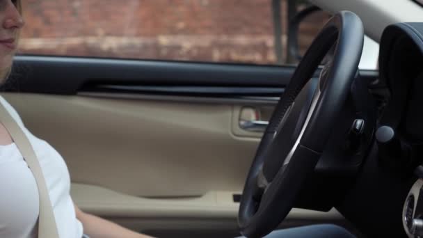 Mujer poniendo sus manos en un volante de cuero negro en un coche de lujo. — Vídeos de Stock