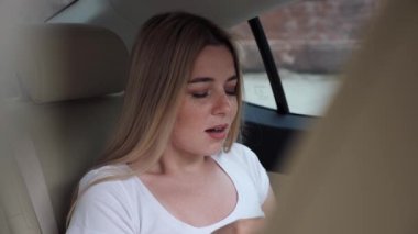 Modern arabada oturan genç bir kadın hapşırığını hisseder ve mendili hasta eder..