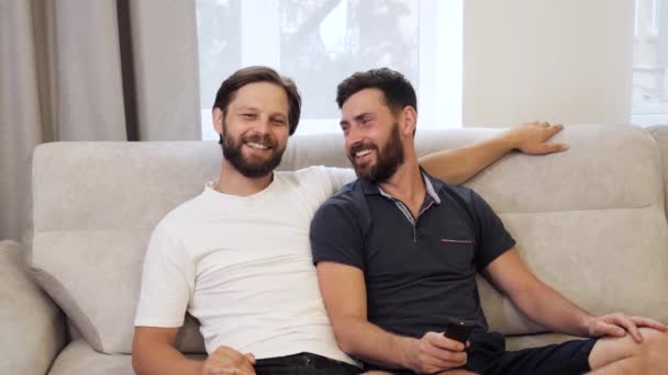 恋爱中的同性男同性恋伴侣在家里看电视很开心. — 图库视频影像