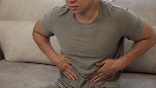Uomo cinese che stringe la pancia con le mani a causa del dolore addominale. — Video Stock