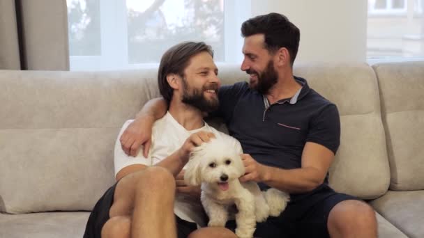 Χρόνος ανάπαυσης Αρχική σελίδα Διαμέρισμα Ευτυχισμένο γκέι ζευγάρι παίζουν με το σκυλί τους. — Αρχείο Βίντεο