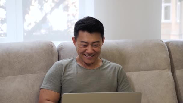 Adulto asiático programador disfruta exitoso inicio sentado en cómodo lugar. — Vídeo de stock