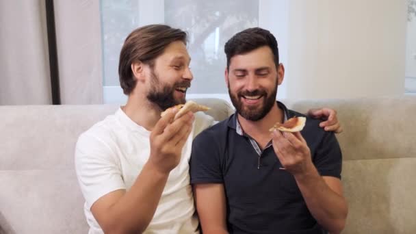 Eşcinsel arkadaşlar kanepede oturup hafta sonunu birlikte pizza yiyerek geçiriyorlar.. — Stok video