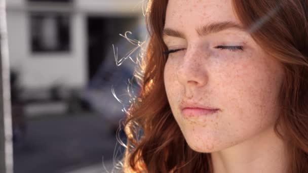 Modelo femenino con belleza natural y pecas en su cara de pie al aire libre. — Vídeo de stock