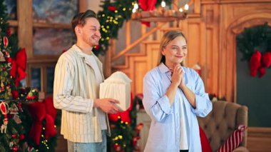 Bir hediye sunulurken, büyük bir sevinç ve minnettarlık getiren hoş bir sürpriz ortaya çıkıyor. Sıcak bir kucaklama, saf mutluluk ve bayram neşesini simgeliyor..