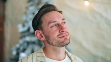 Genç adam nazikçe gülümseyerek yukarı bakıyor. Umudu, huzuru ve memnuniyeti ifade eder. İlham, gelecek ve sessiz yansıma kavramları için ideal. Sakin tavır aşikar..