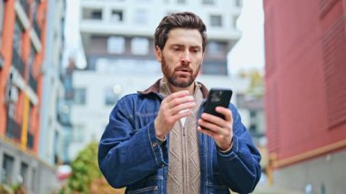 Şehir merkezi, insan akıllı telefondan gelen mesaja tepki veriyor. Şaşkınlık, şaşkınlık, hayal kırıklığı ve stresi gösterir. Dijital bilgi konusunda derinden endişelidir..