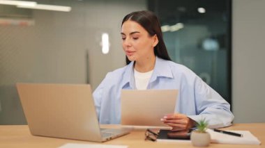 Kendine güvenen tasarımcı masadaki önemli belgeleri dikkatle inceliyor. Çalışkan çalışma başarılı iş operasyonlarına katkıda bulunur. Bağlılık ve düşünceli bir analiz gösteriyor..