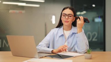 Odaklanmış bir profesyonel sesli mesaj dinler, özenle notlar yazar. Modern ofis ortamında özgül bireysel yönetim görevlerini verimli bir şekilde gösterir. Verimli ve özenli bir çalışma sunar..