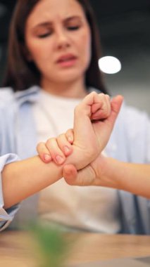 Kadın şiddetli bilek ağrısından muzdarip. Masaj eklemlerinde bariz bir rahatsızlık var. Acı çeken bir ifade hayal kırıklığını ve rahatlama ihtiyacını gösterir. Rahatsızlık ve rahatlama belirtileri.