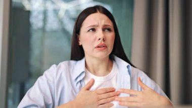 Kadın nefes almakta zorlanıyor, elini göğsüne koyuyor. Acıyı, nefes darlığını, anksiyeteyi ve rahatsızlığı ifade eder. Hastalık belirtileri, acil rahatlama ihtiyacı.