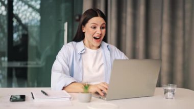 Genç profesyonel dizüstü bilgisayarda çalışırken inanılmaz bir heyecan ve neşe yaşıyor. Zaferi, mutluluğu ve duyguyu ifade eder. İş kavramları, çevrimiçi başarı.