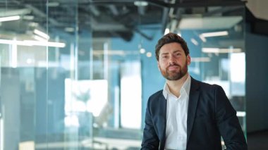 Gülümseyen iş adamları modern bir ofiste güven, mutluluk ve başarı yayar. Dizüstü bilgisayar tutmak, gülümsemek profesyonelliği, liderliği ve pozitif kurumsal ortamı temsil eder..