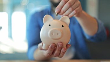 Eller dikkatle kumbaraya para koysun. Finansal planlamayı, gelecekteki yatırımı, güvenliği sembolize ediyor. Büyümeye, sorumluluğa, umuda ve akıllı para yönetimine odaklan. Pozitif finansal alışkanlıklar.