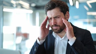 Profesyonel iş adamları acı verici baş ağrılarına, yoğun strese katlanır. Yorgun görünüyor, iş talepleri ve teslim tarihleri konusunda endişeli. Baskıdan, rahatsızlıktan, yorgunluktan kurtulmak istiyor..