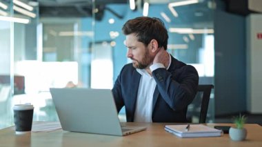 Profesyonel deneyimler, modern ofiste dizüstü bilgisayar üzerinde çalışırken sürekli boyun ağrısı ve rahatsızlığını gösterir..