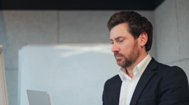 Profesyonel, düşünceli, işine odaklanmış. İş adamı, modern ofiste odaklanma ve kararlılık gösteren fikirler üzerinde kafa yorar. Yansıtıcı düşünceler stratejik kararlara yol açar, başarıyı öngörür..