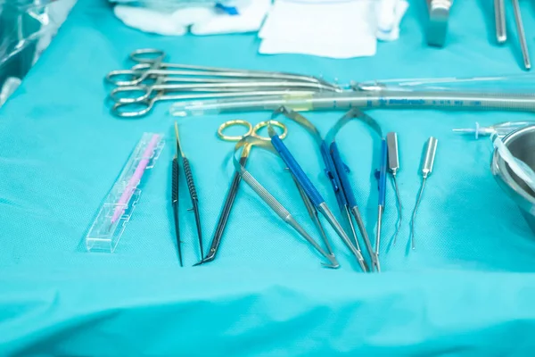 Medical team performing operation. Close up of scrub nurse taking medical instruments for operation. Medical and instrumentalist nurse working in an operating room with scissors of surgery.