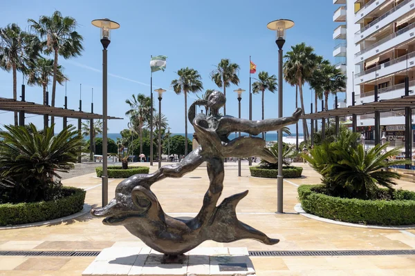 MARBELLA, ANDALUCIA / ESPAÑA - 23 DE MAYO: El hombre sobre la estatua del delfín — Foto de Stock