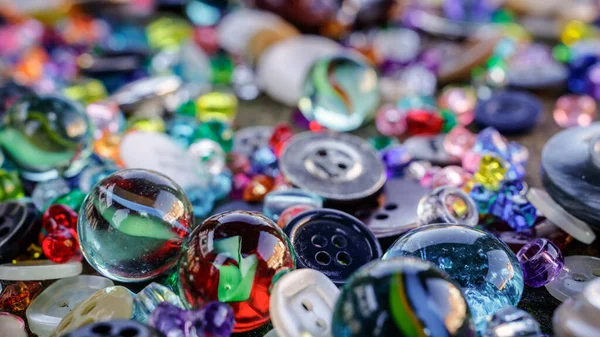 A group of randomly scattered beads, buttons and marbles