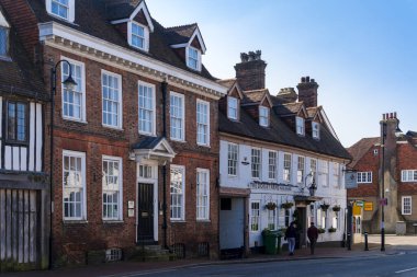 EAST GRINSTEAD, Batı SUSSEX, İngiltere - 1 Mart 2021 tarihinde Doğu Grinstead 'de Coronavirus salgını nedeniyle kapalı bir bar ve ofislerin görüntüsü. Kimliği belirsiz iki kişi.