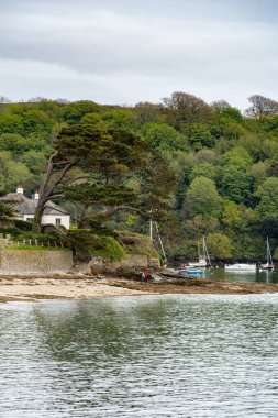 St. Mawes, Cornwall 'a 12 Mayıs 2021' de demir atmış tekneler. Kimliği belirsiz iki kişi.