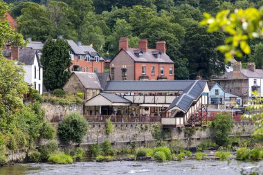 LLANGOLLEN, DENBIGHSHIRE, WALES - 11 Temmuz 2021 'de Dee Nehri' nin karşısındaki LLangollen, Galler 'deki eski istasyona bakın. Tanımlanamayan kişiler