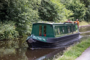 LLANGOLLEN, DENBIGHSHIRE, WALES - JULY 11 : Narrow boat on the Llangollen canal near Llangollen, Wales on July 11, 2021. Two unidentified people clipart