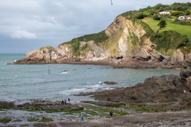 COMBE MARTIN, DEVON, İngiltere - 17 Ağustos 2021 'de Devon' daki Combe Martin 'de kıyı şeridinin tadını çıkaran insanlar. Tanımlanamayan kişiler