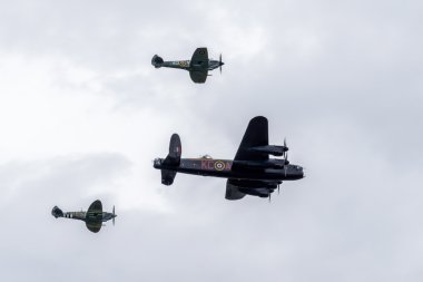 Avro lancaster iki spitfires tarafından çevrili.