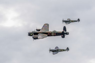 Avro lancaster iki spitfires tarafından çevrili.