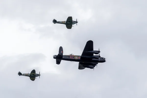 Avro lancaster flankerad av två Spitfire — Stockfoto