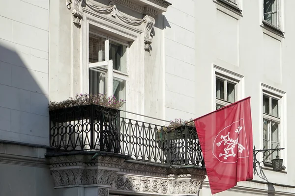 Bandera roja ondeando desde un edificio en Cracovia —  Fotos de Stock