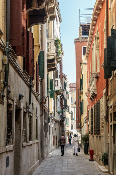 People walking along a narrow street in Venice