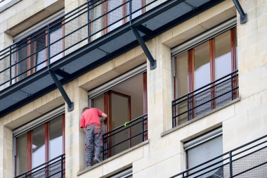 Berlin'de bir balkon onarımı yürüten adam