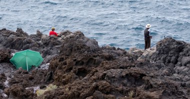 Men fishing in Callao Salveje Tenerife clipart