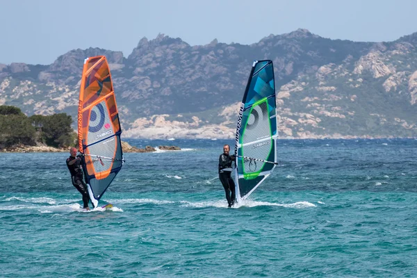 Dos hombres haciendo windsurf en Porto Pollo en Cerdeña el 21 de mayo de 2015 . — Foto de Stock