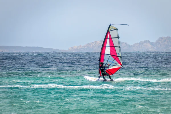 Hombre windsurf en Porto Pollo en Cerdeña en mayo 21, 2015 — Foto de Stock