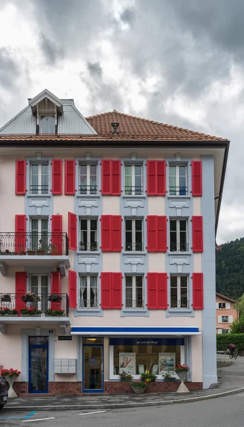 VALLORBE,/ EUROPE - SEPTEMBER 14: Building with red shutters in — Zdjęcie stockowe