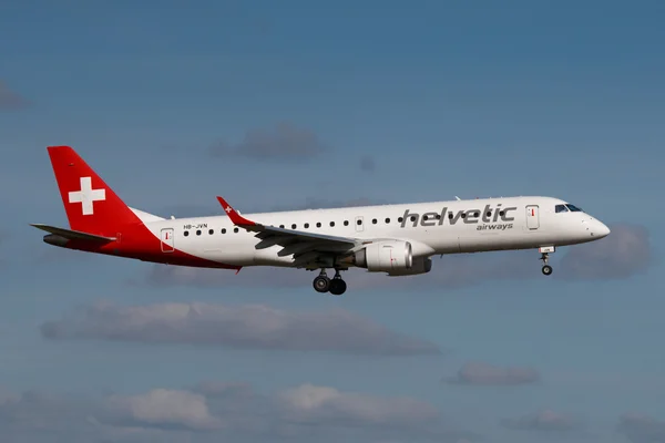 Praag, Tsjechische Republiek-30 augustus: Helvetic Airlines Embraer E190 landt op de luchthaven van PRG op 30 augustus 2016 in Praag, Tsjechië. Helvetic Airways is een Zwitserse luchtvaartmaatschappij gevestigd op Zurich Airport. — Stockfoto