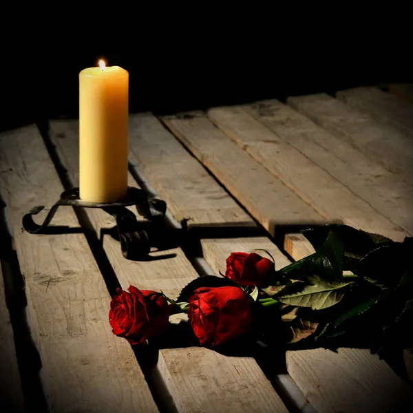 赤いバラと木製のボード上のキャンドルはお祝いや喪に見えることができます — ストック写真