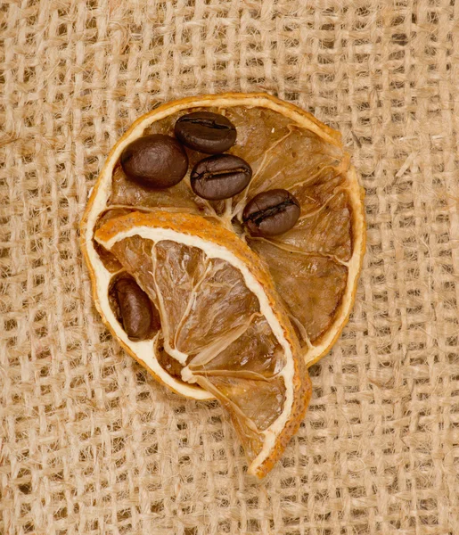 Lemons and coffee beans on burlap — Stock Photo, Image