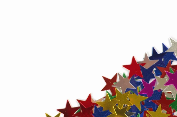 Estrelas de confete coloridas contra branco — Fotografia de Stock